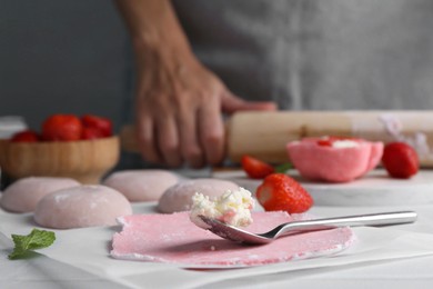 Photo of Woman making tasty mochi at table, closeup