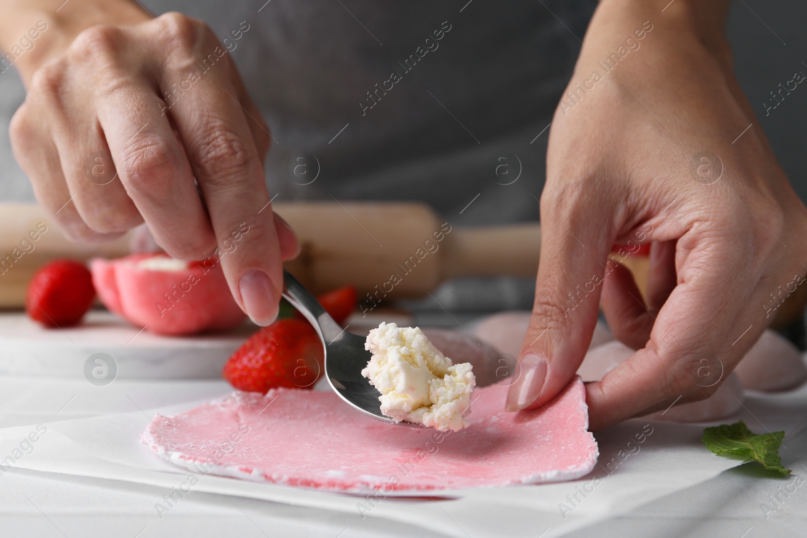 Photo of Woman making tasty mochi at table, closeup