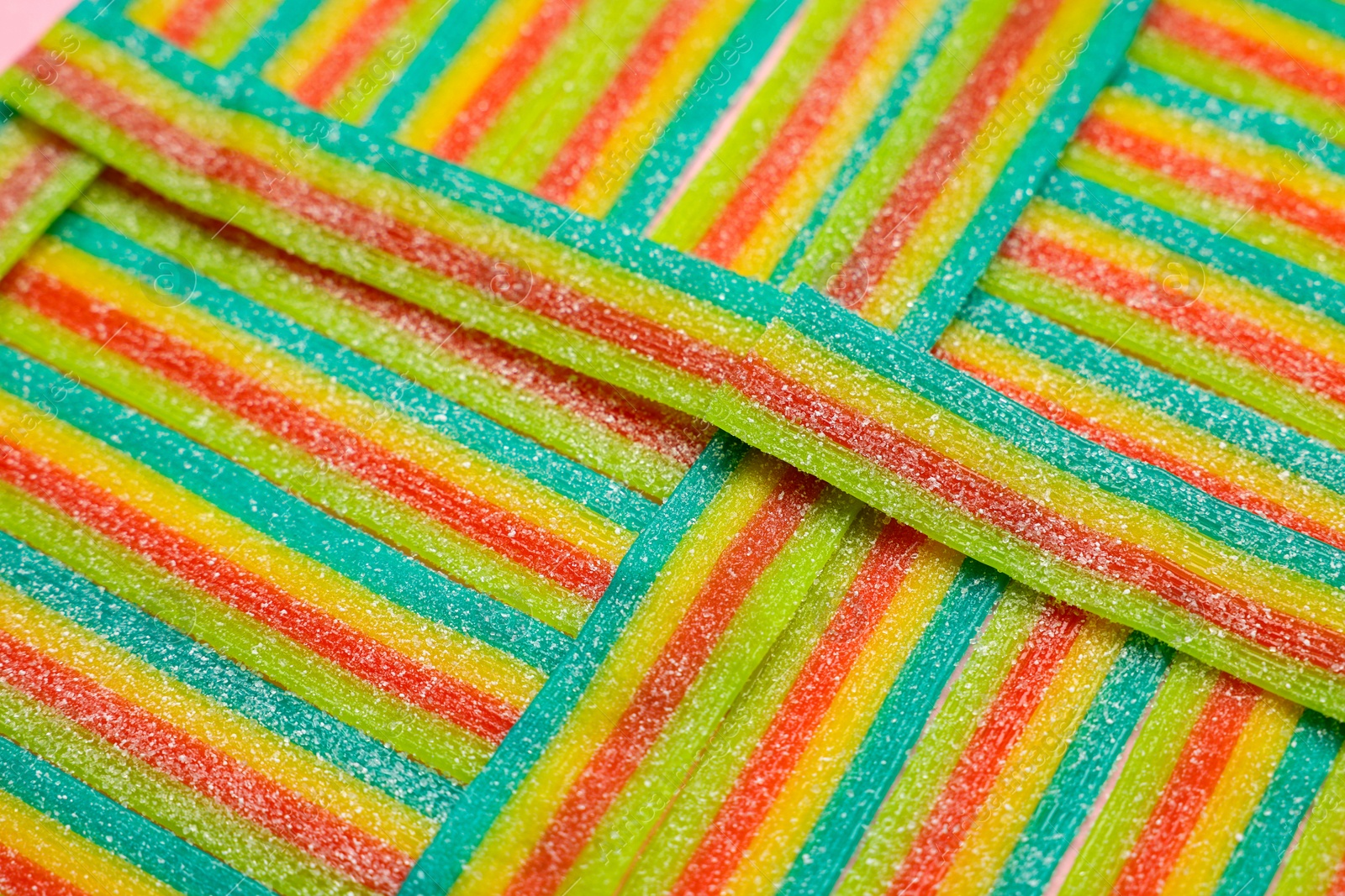 Photo of Tasty rainbow sour belts as background, closeup