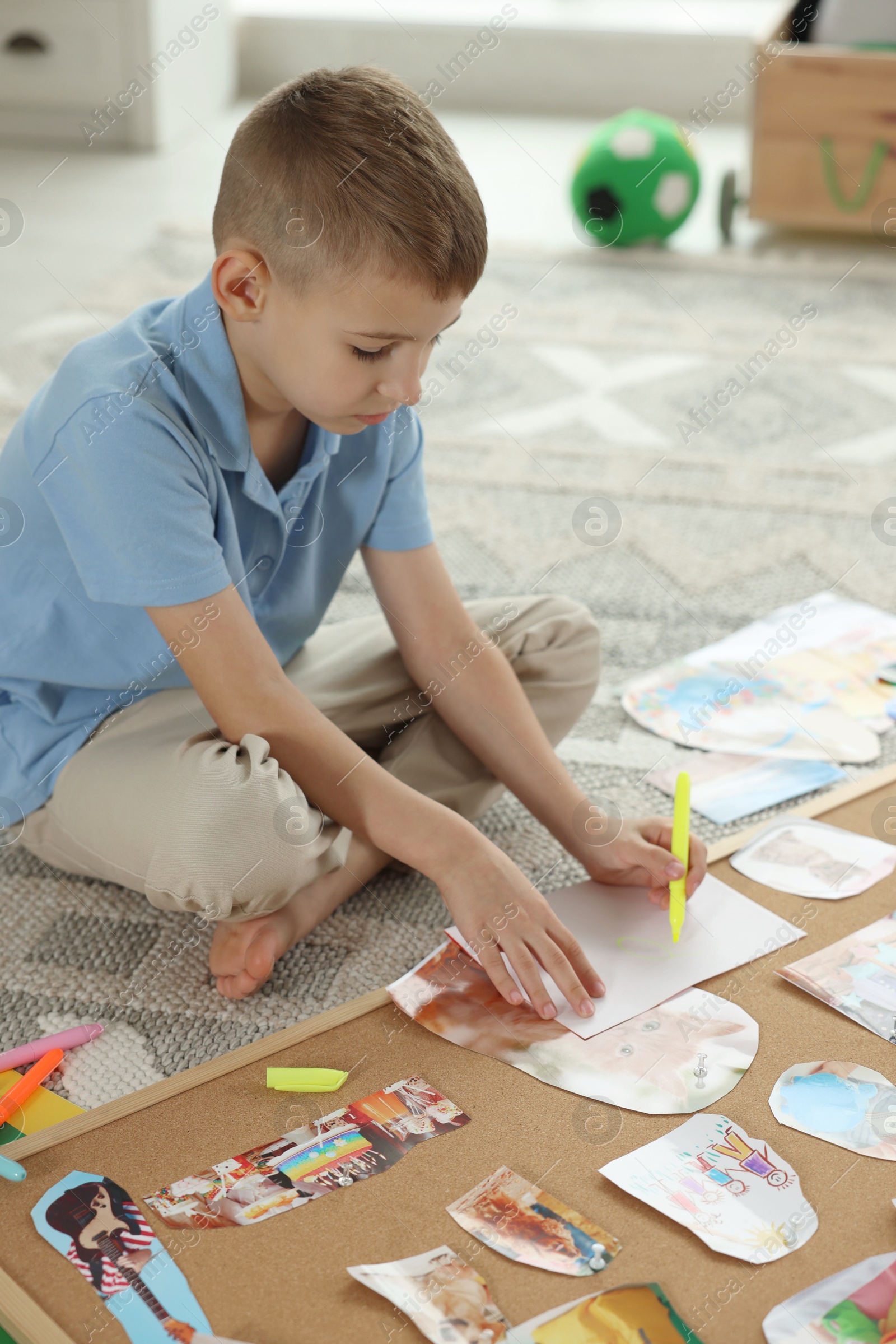 Photo of Creating vision board. Little boy drawing on paper indoors