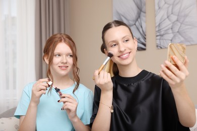 Photo of Beautiful teenage girls doing makeup at home