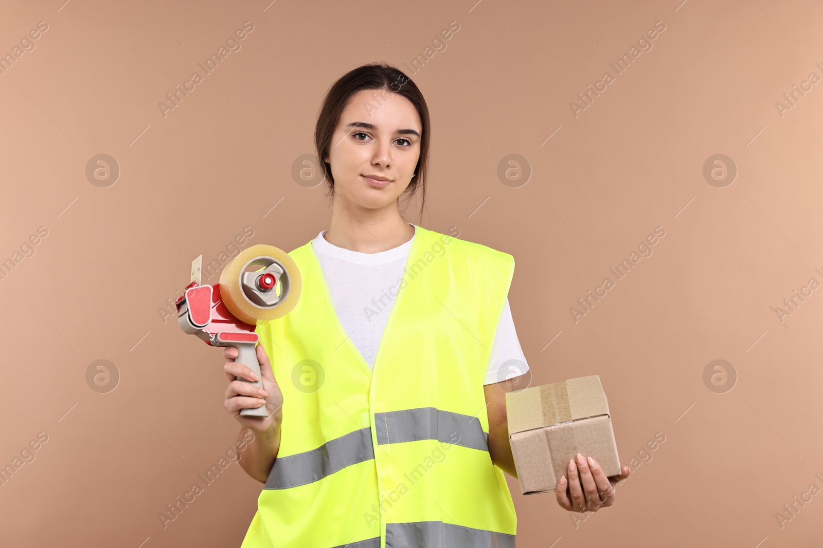 Photo of Girl in uniform with adhesive tape and parcel on pale brown background. Work for teenagers