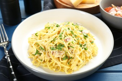 Photo of Delicious pasta Carbonara served on blue wooden table, closeup