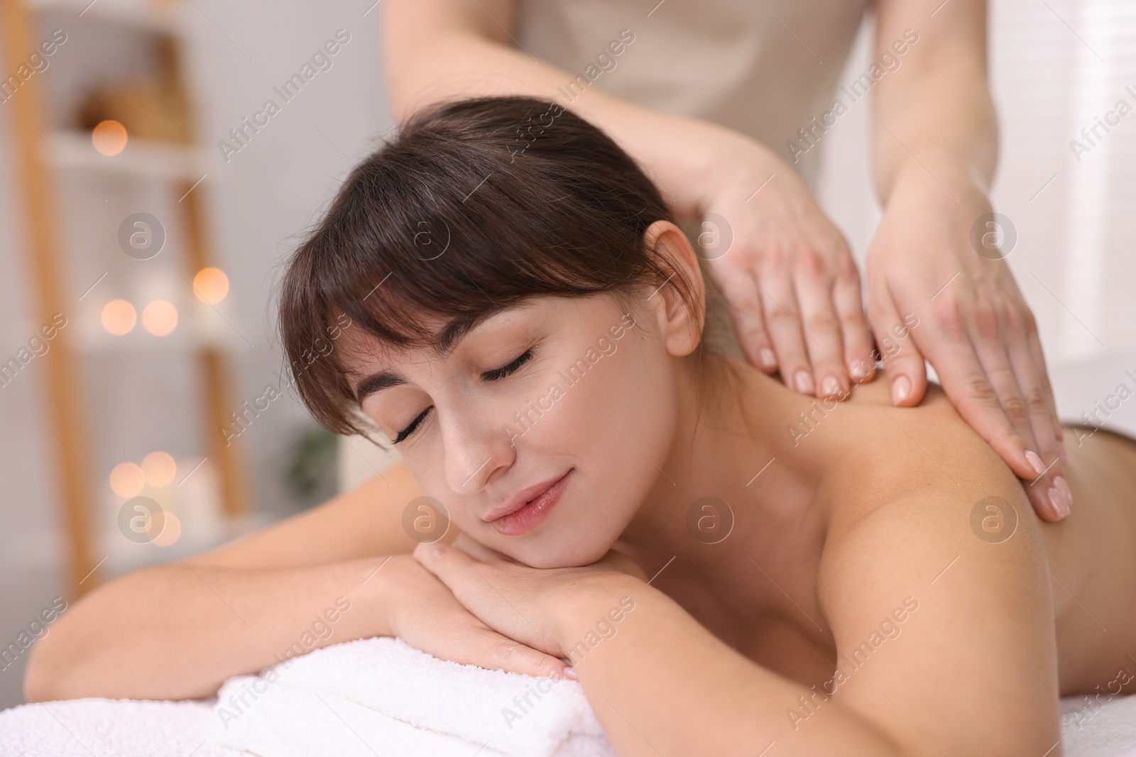 Photo of Young woman receiving massage in spa salon