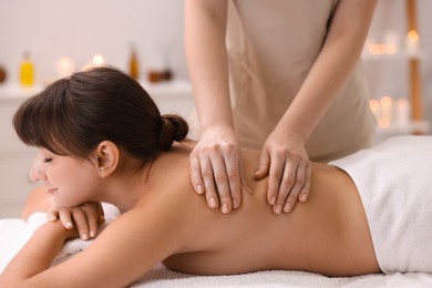 Photo of Young woman receiving massage in spa salon