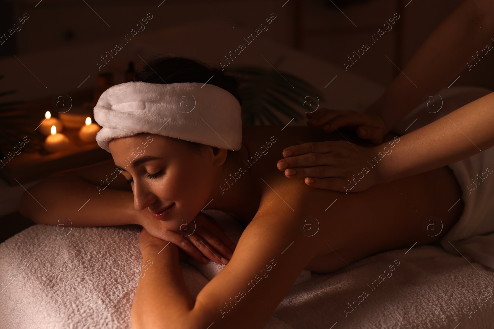 Photo of Young woman receiving back massage in spa salon