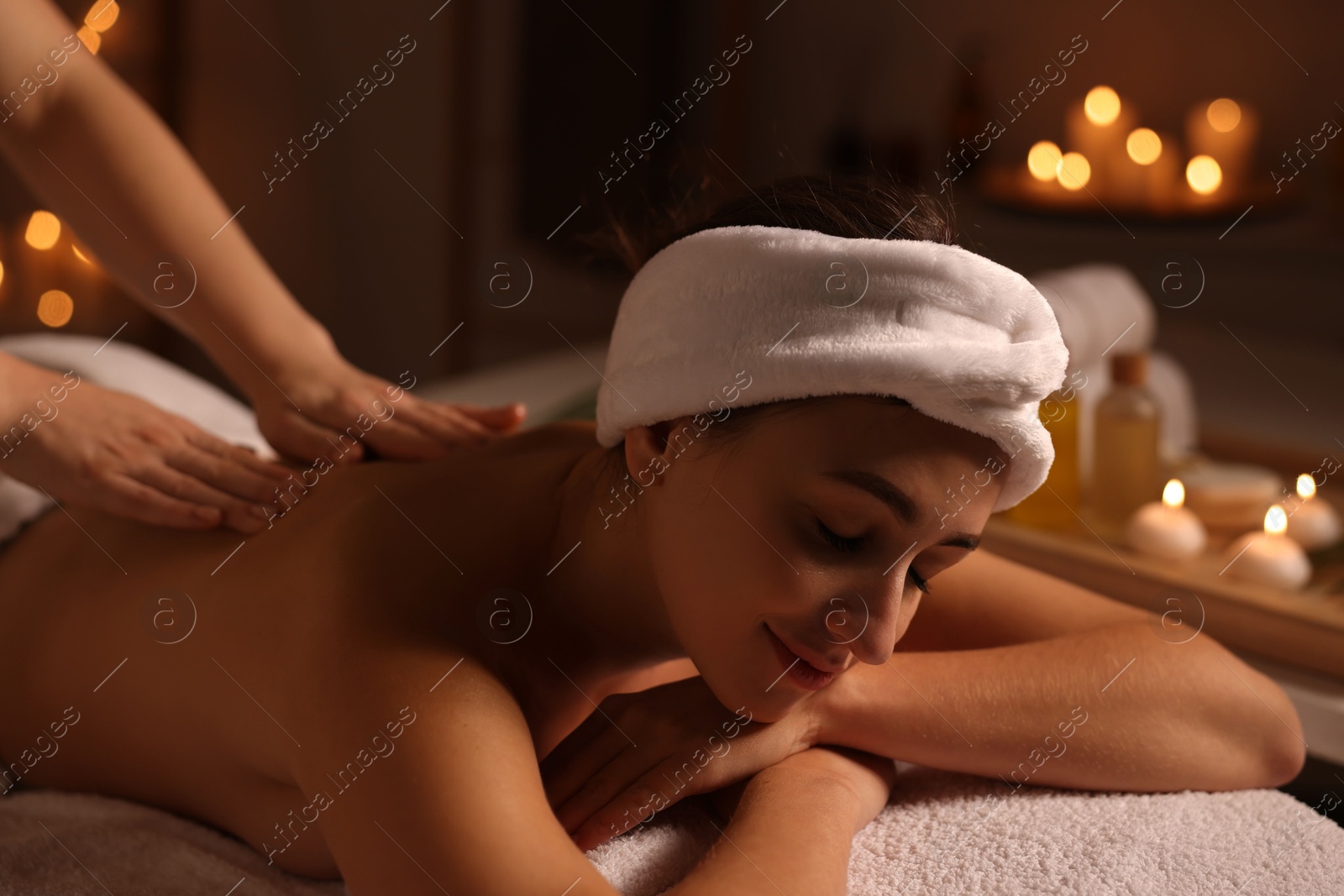 Photo of Young woman receiving back massage in spa salon