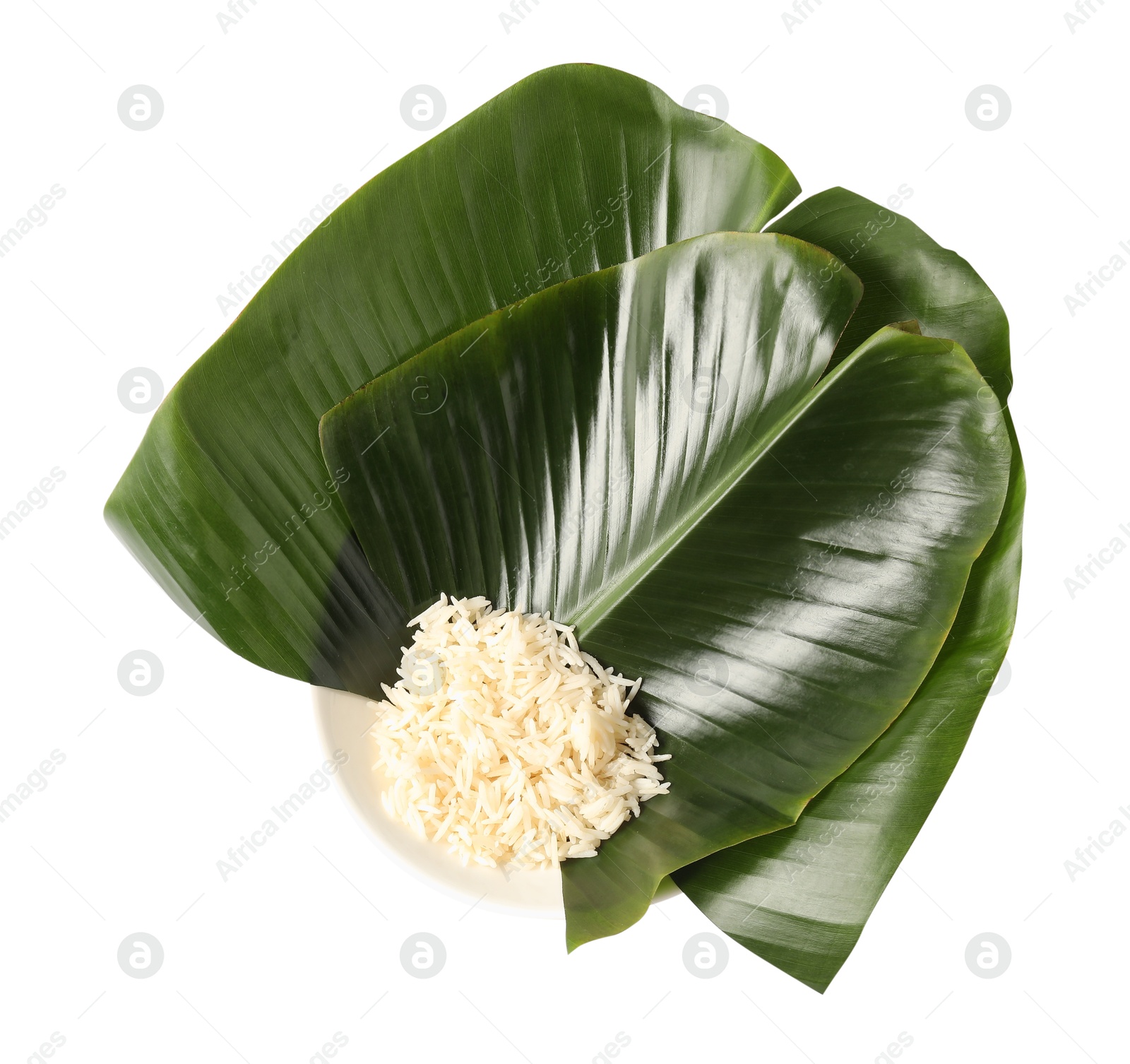 Photo of Cut banana leaves with rice in bowl isolated on white, top view. Healthy eco serving