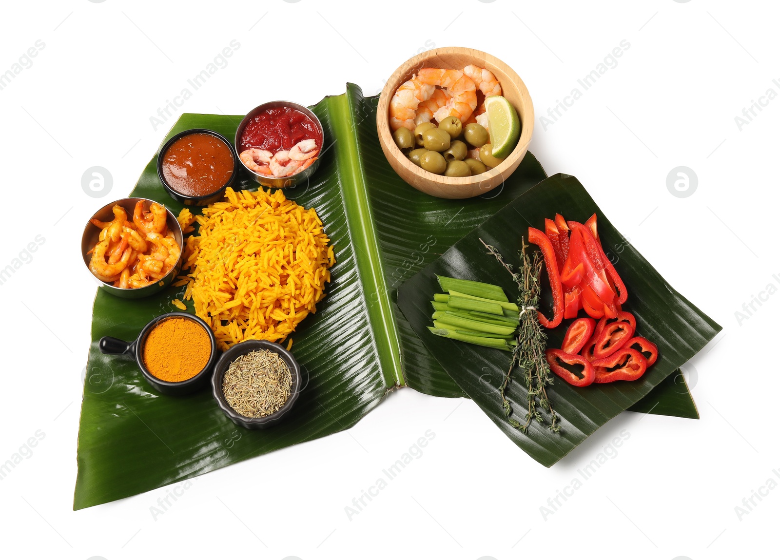 Photo of Piece of banana leaf with different food, spices and sauce isolated on white, top view. Healthy eco serving