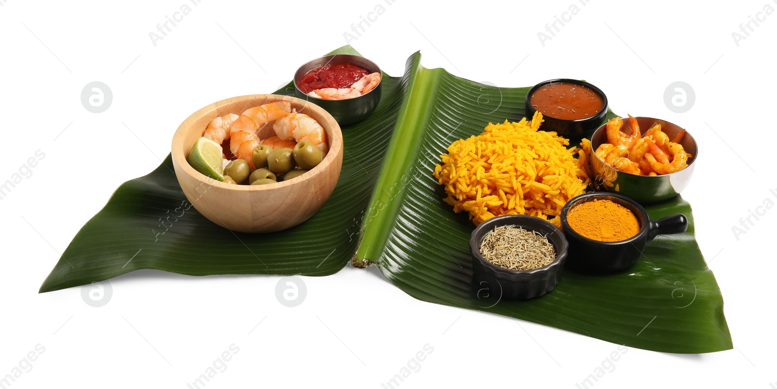 Photo of Piece of banana leaf with different food, spices and sauce isolated on white. Healthy eco serving