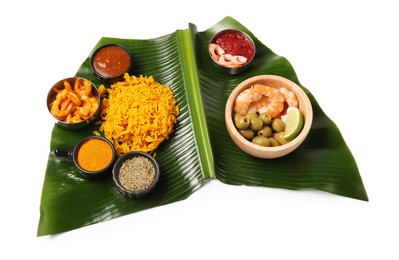 Photo of Piece of banana leaf with different food, spices and sauce isolated on white, above view. Healthy eco serving