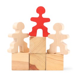 Photo of Human figures on wooden blocks, red one on top against white background. Competition concept