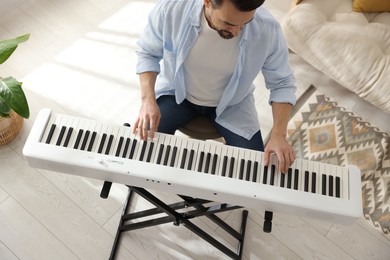 Photo of Man playing synthesizer at home, above view