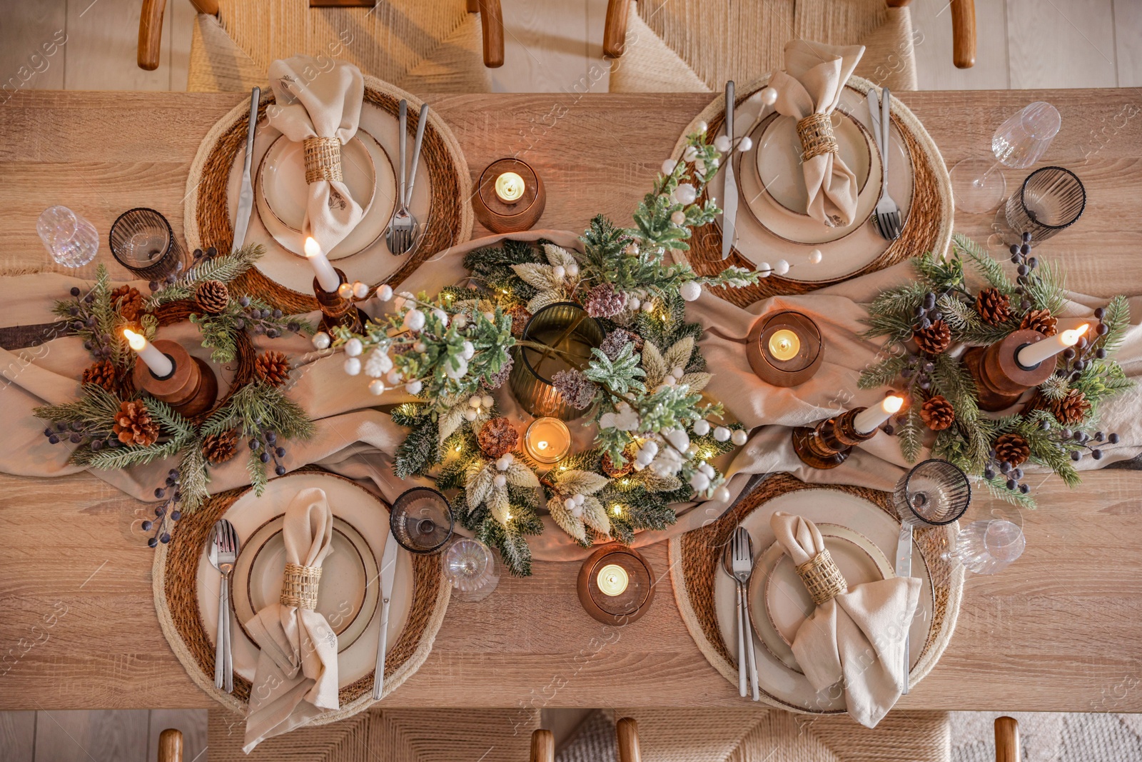 Photo of Christmas celebration. Festive table setting with dishware, glasses and decor in room, top view