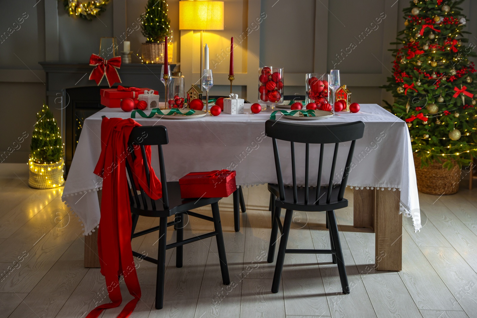 Photo of Christmas celebration. Festive table setting with dishware, glasses and decor