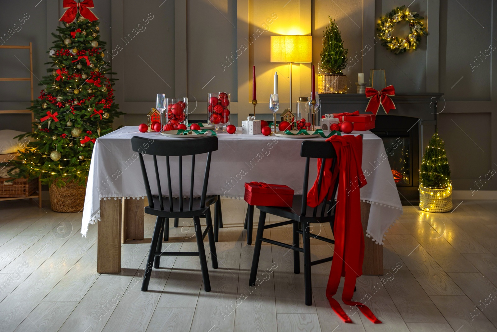 Photo of Christmas celebration. Festive table setting with dishware, glasses and decor