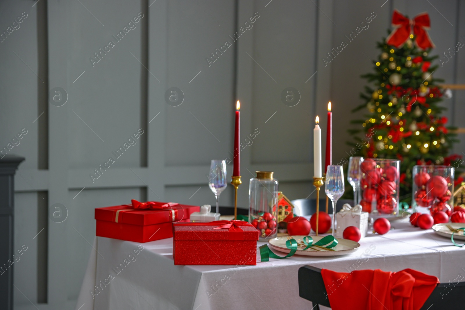 Photo of Christmas celebration. Festive table setting with dishware, glasses and decor