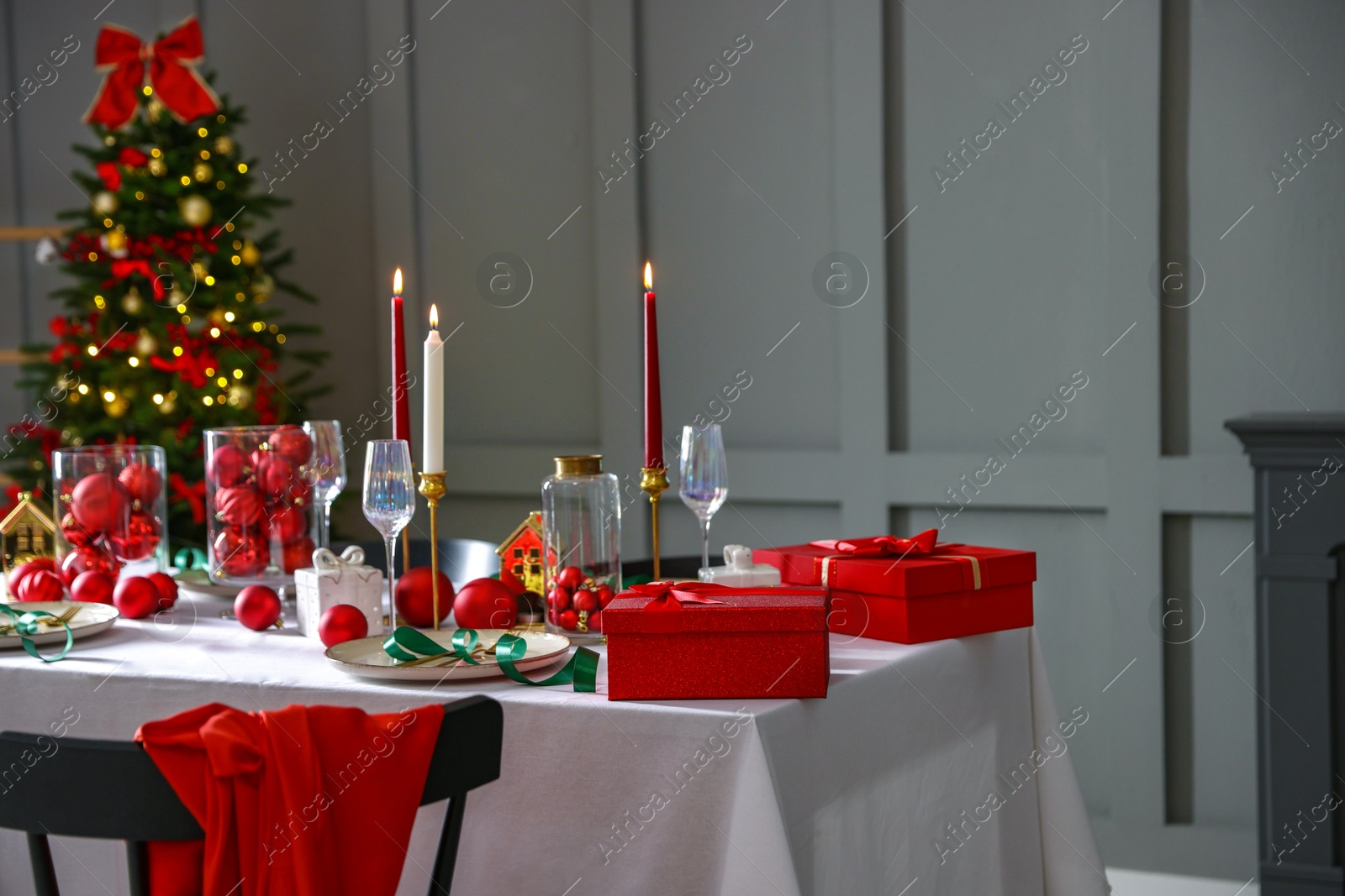 Photo of Christmas celebration. Festive table setting with dishware, glasses and decor