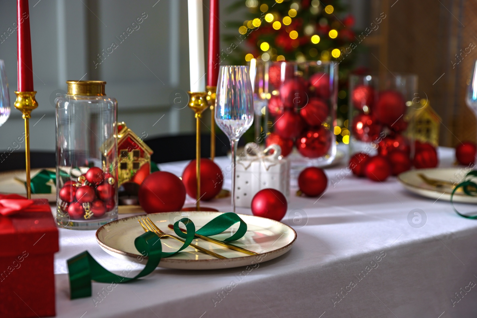 Photo of Christmas place setting with festive decor on table in room