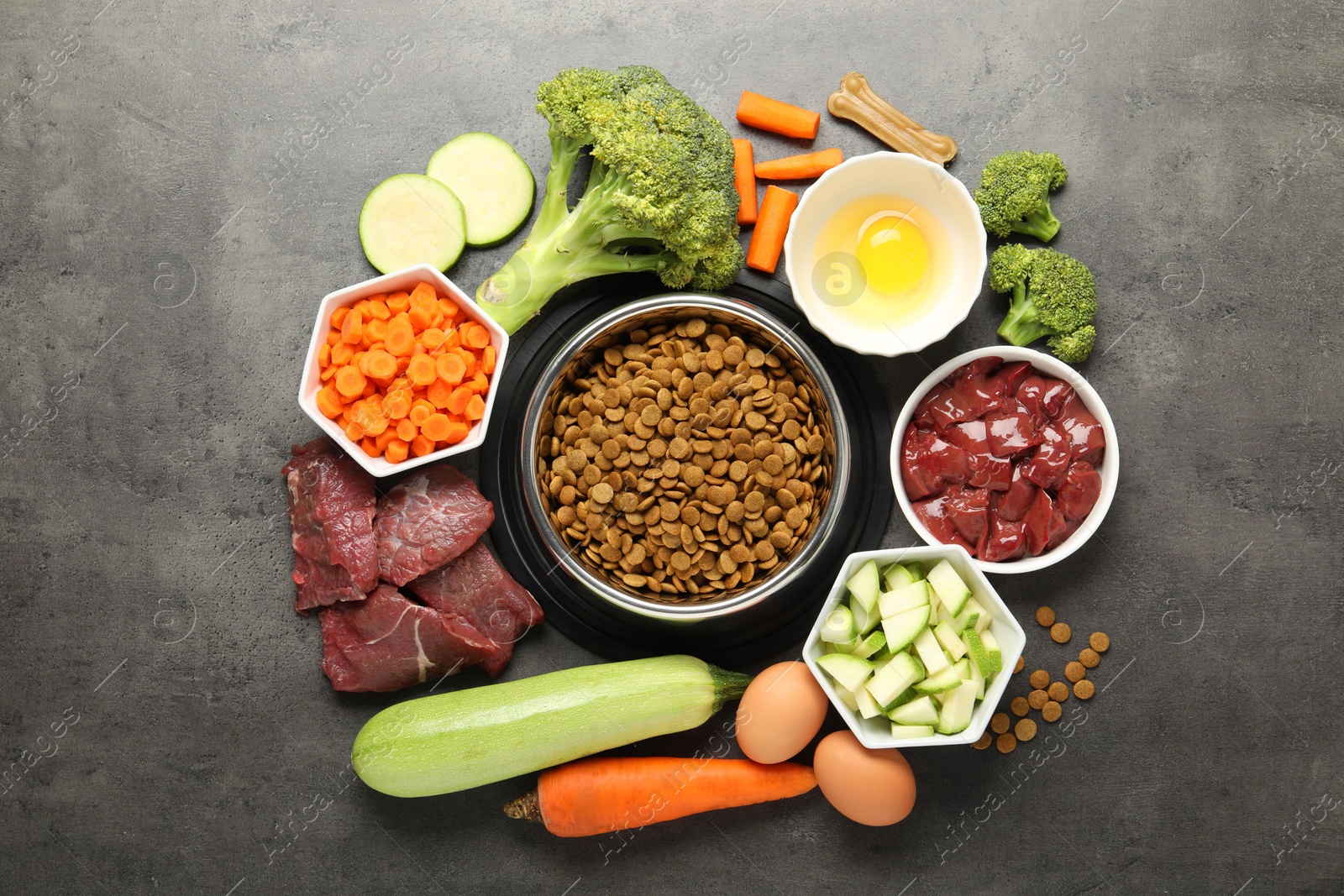 Photo of Dry pet food and natural products on grey table, top view