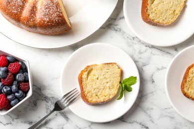 Photo of Freshly baked sponge cake, mint and berries on white marble table, top view