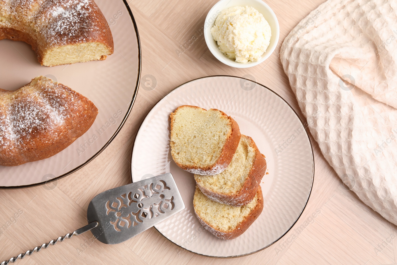 Photo of Pieces of freshly baked sponge cake, server and ice cream on wooden table, top view