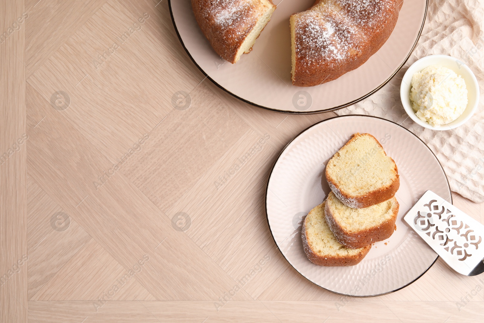 Photo of Pieces of freshly baked sponge cake, server and ice cream on wooden table, top view. Space for text