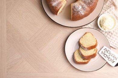 Photo of Pieces of freshly baked sponge cake, server and ice cream on wooden table, top view. Space for text