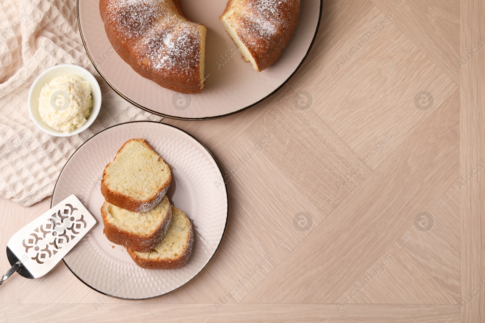 Photo of Pieces of freshly baked sponge cake, server and ice cream on wooden table, top view. Space for text