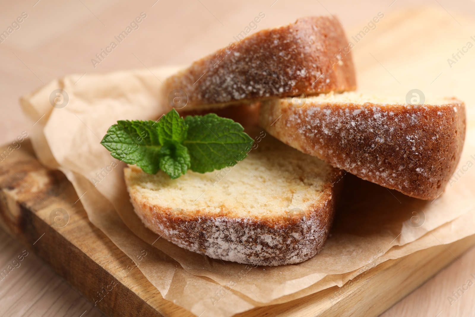 Photo of Pieces of freshly baked sponge cake and mint on table, closeup