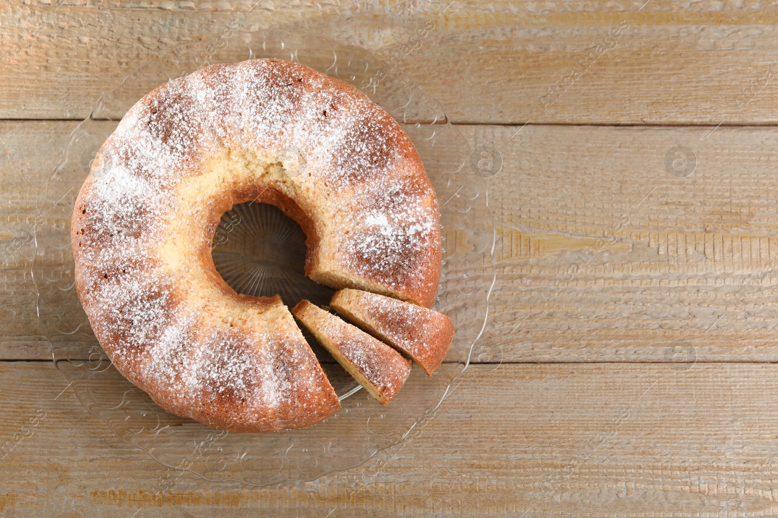 Photo of Freshly baked sponge cake on wooden table, top view. Space for text