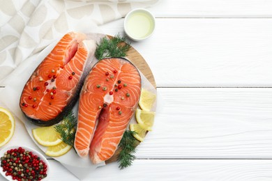 Photo of Fresh raw salmon steaks with spices, lemon and dill on white wooden table, flat lay. Space for text