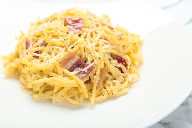 Photo of Delicious pasta Carbonara with bacon on plate, closeup