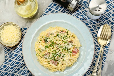 Photo of Delicious pasta Carbonara with bacon served on gray textured table, flat lay