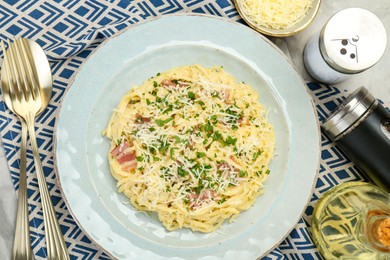 Photo of Delicious pasta Carbonara with bacon served on gray textured table, flat lay