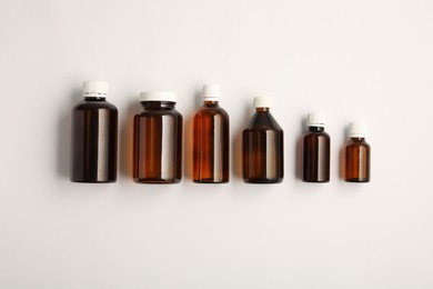 Photo of Medical bottles with medicine on white background, top view