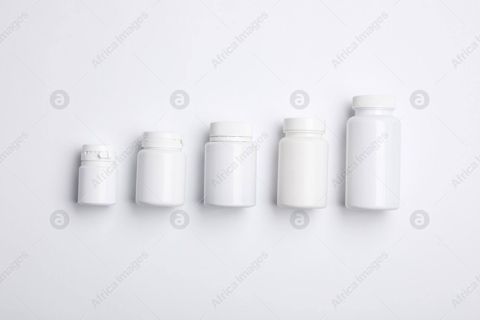 Photo of Many plastic medical bottles on white background, top view