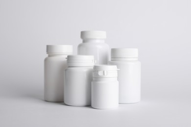 Photo of Many plastic medical bottles on white background