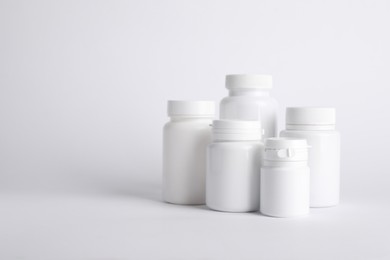 Photo of Many plastic medical bottles on white background, space for text