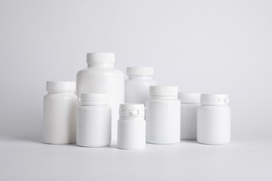 Photo of Many plastic medical bottles on white background