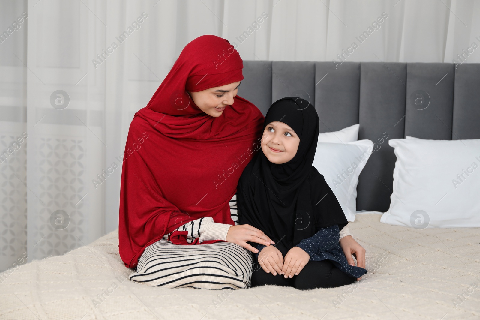 Photo of Muslim woman and her daughter spending time together at home