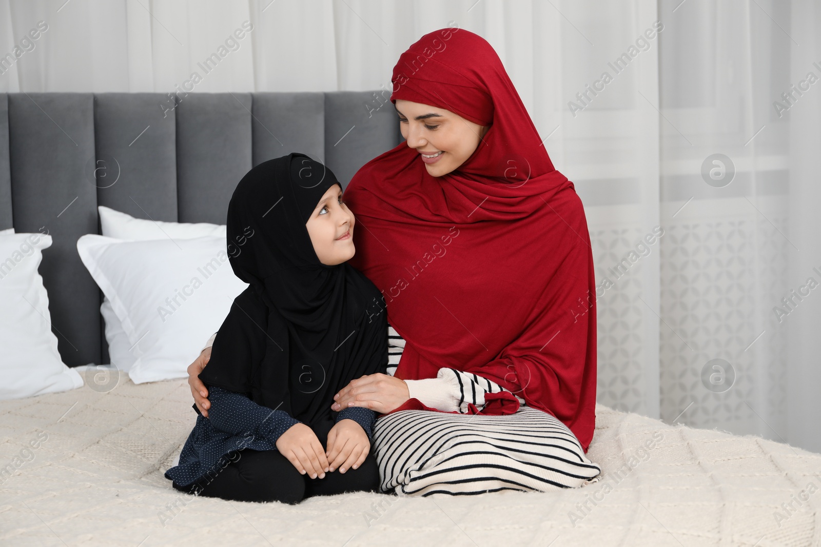 Photo of Muslim woman and her daughter spending time together at home