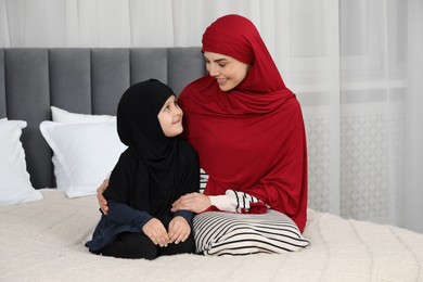 Photo of Muslim woman and her daughter spending time together at home