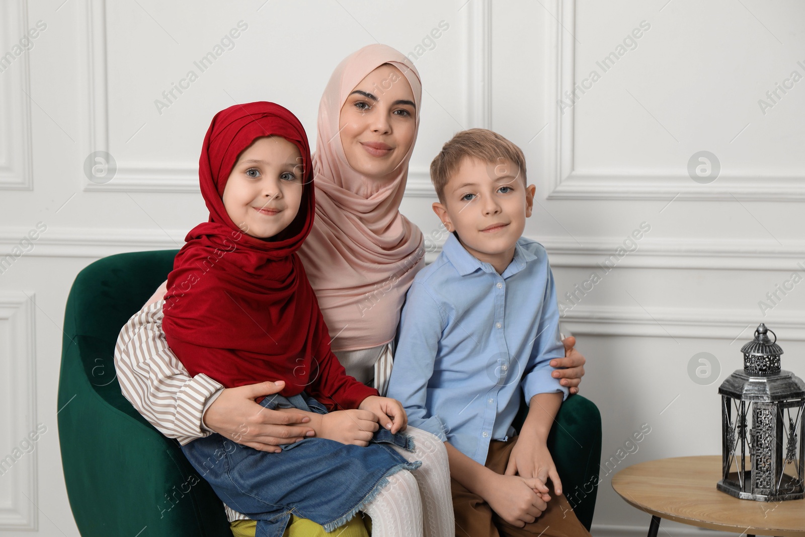 Photo of Muslim woman and her children spending time together at home