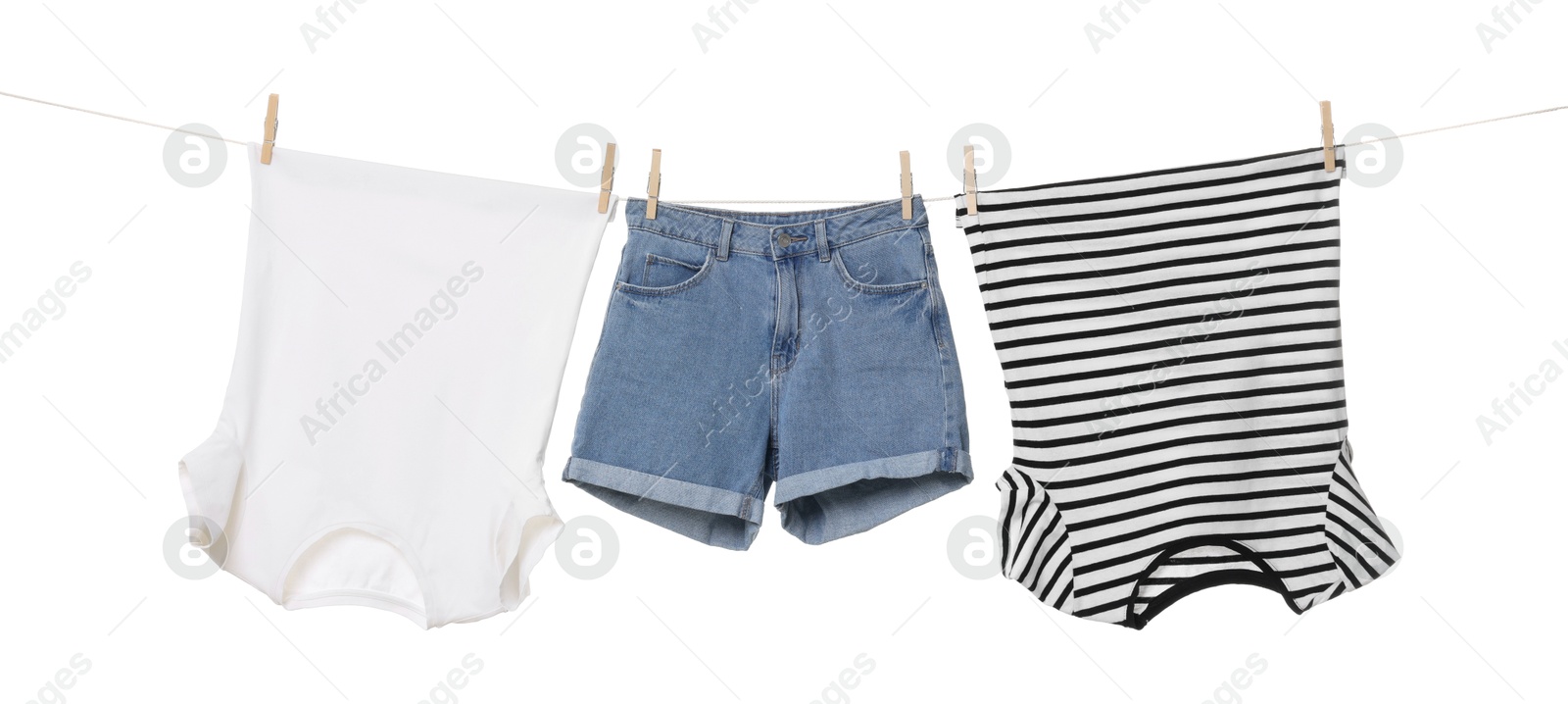 Photo of Different clothes drying on laundry line against white background