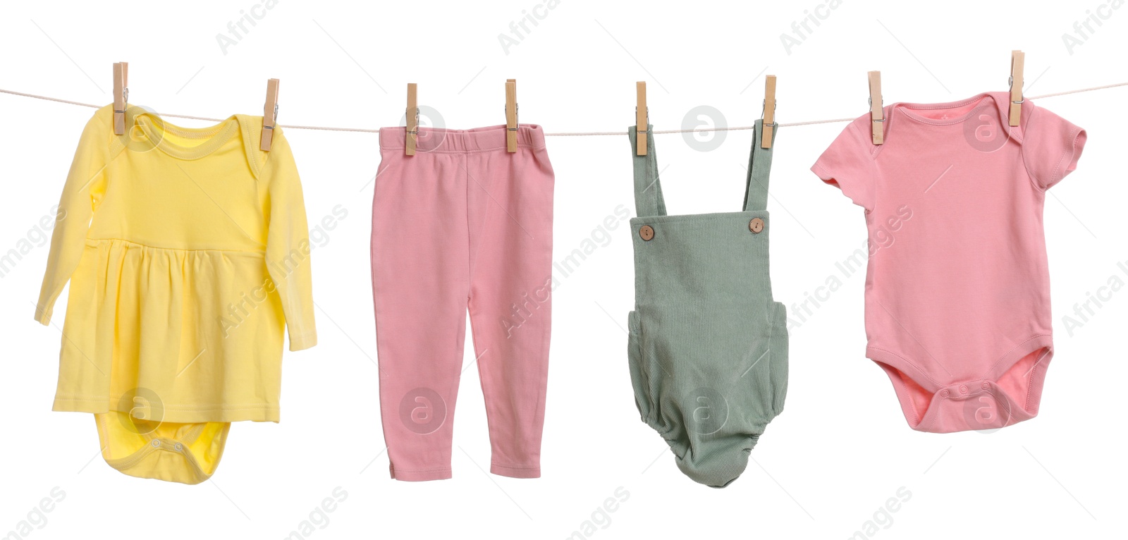 Photo of Different baby clothes drying on laundry line against white background