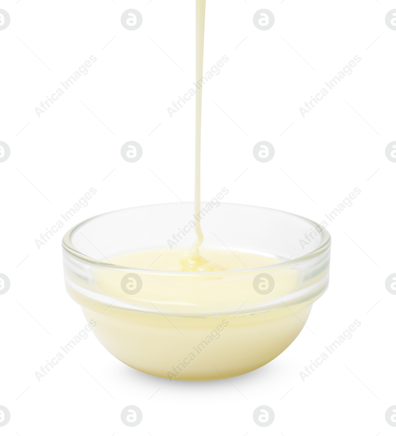 Photo of Pouring condensed milk into bowl isolated on white