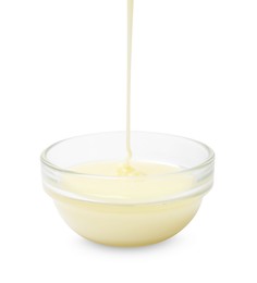 Photo of Pouring condensed milk into bowl isolated on white