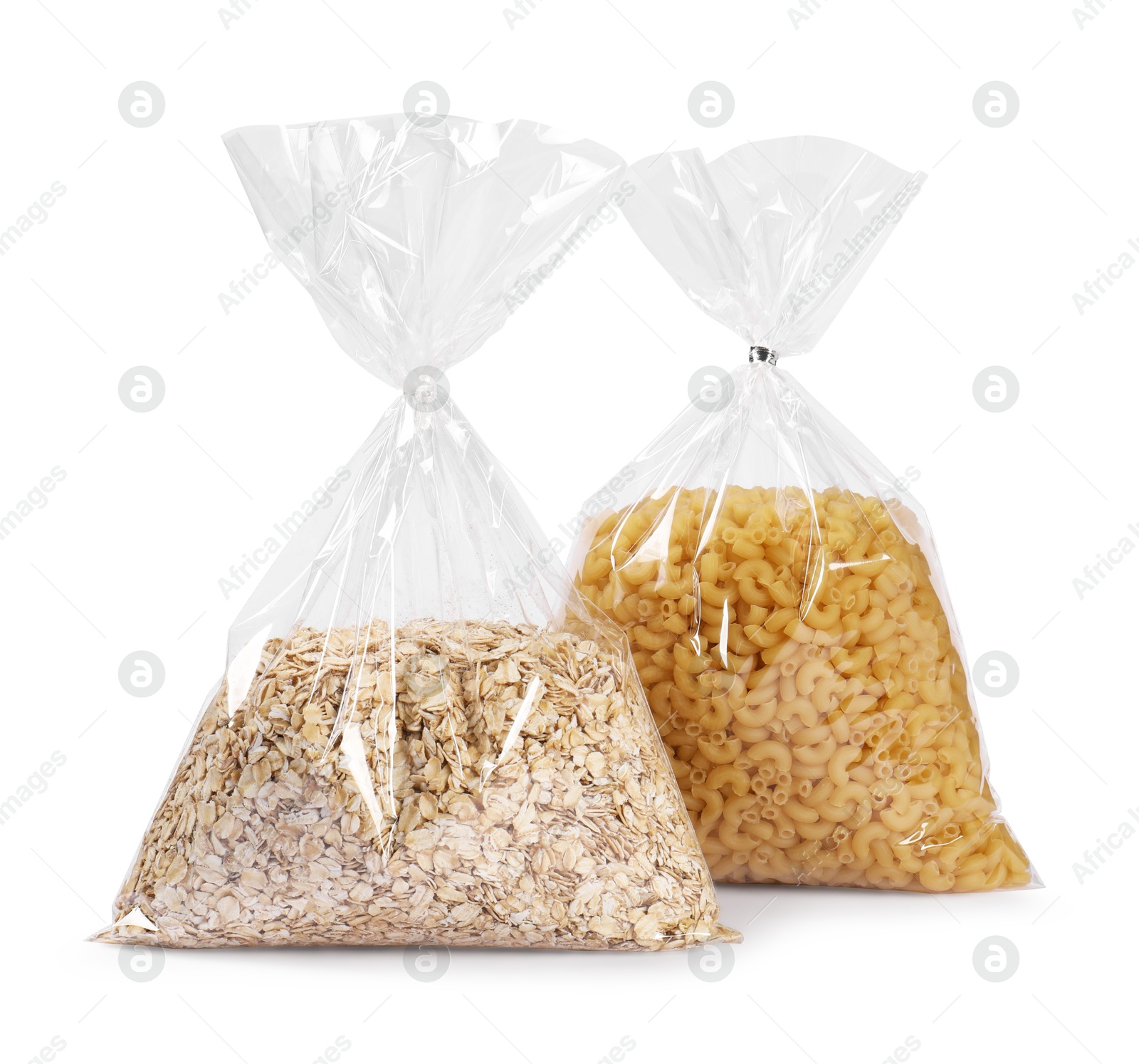 Photo of Plastic bags with pasta and oat flakes isolated on white