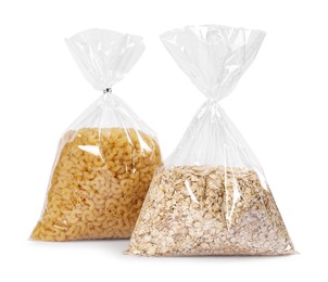 Photo of Plastic bags with pasta and oat flakes isolated on white